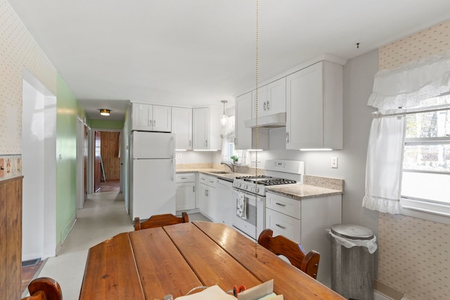 kitchen featuring white appliances, light stone countertops, sink, and white cabinets