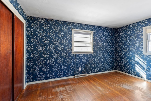 unfurnished bedroom with wood-type flooring and a closet