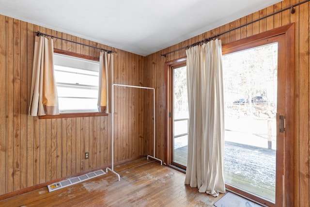 empty room featuring hardwood / wood-style flooring and wooden walls