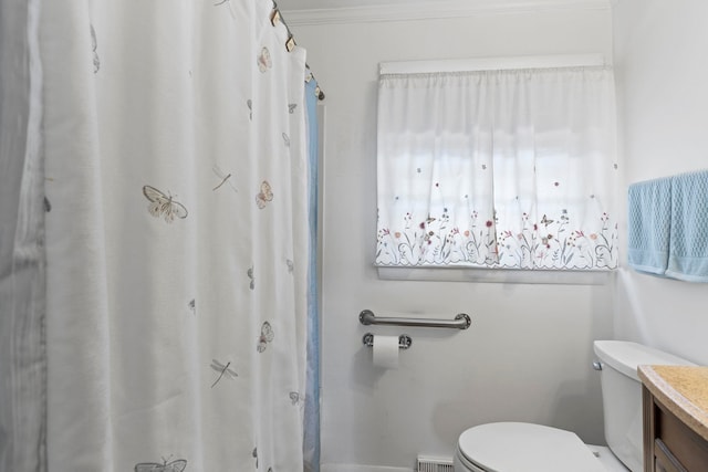 bathroom with vanity, ornamental molding, and toilet