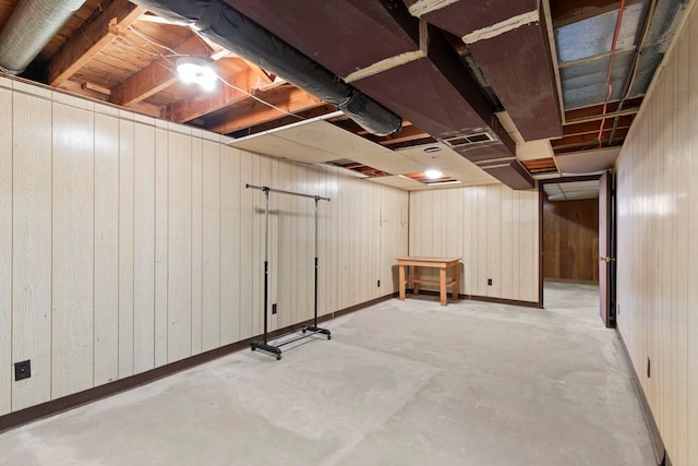 basement featuring wooden walls