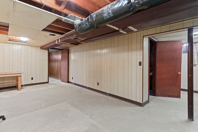 basement featuring wood walls