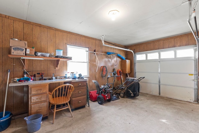 garage featuring wooden walls and a workshop area