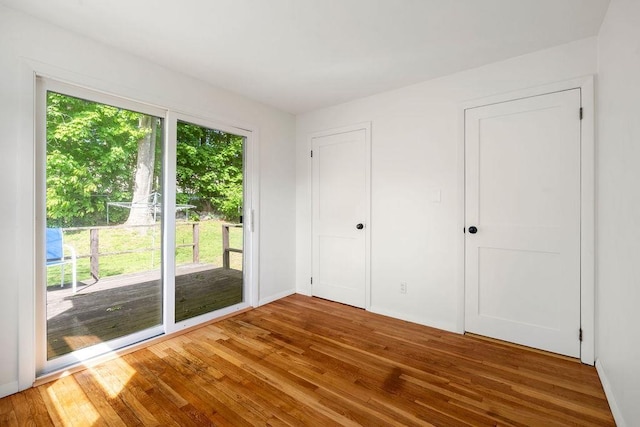 50 Suzanne Dr, Portsmouth, NH 03801 - unfurnished bedroom with access to exterior, wood finished floors, and baseboards