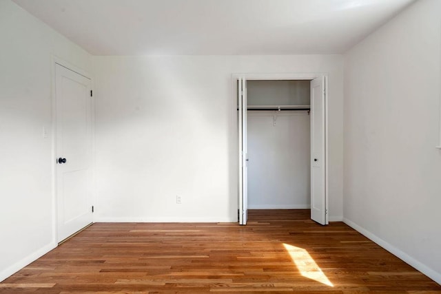 50 Suzanne Dr, Portsmouth, NH 03801 - unfurnished bedroom featuring wood finished floors, baseboards, and a closet