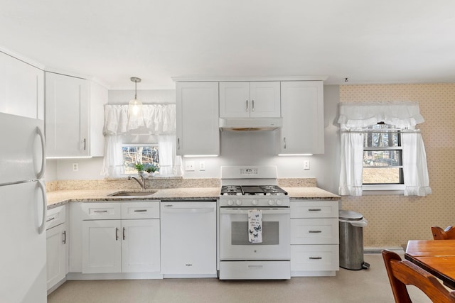 kitchen with white appliances, sink, hanging light fixtures, and white cabinets