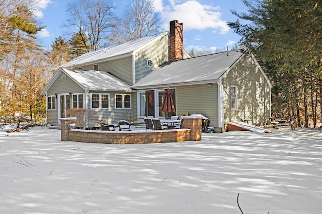 view of snow covered rear of property