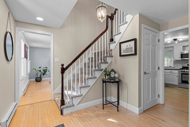 entryway with light wood-type flooring and baseboard heating