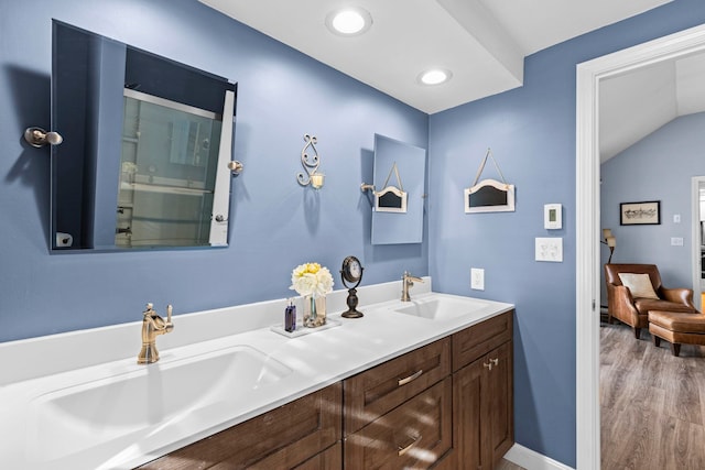 bathroom with vanity, hardwood / wood-style floors, and vaulted ceiling