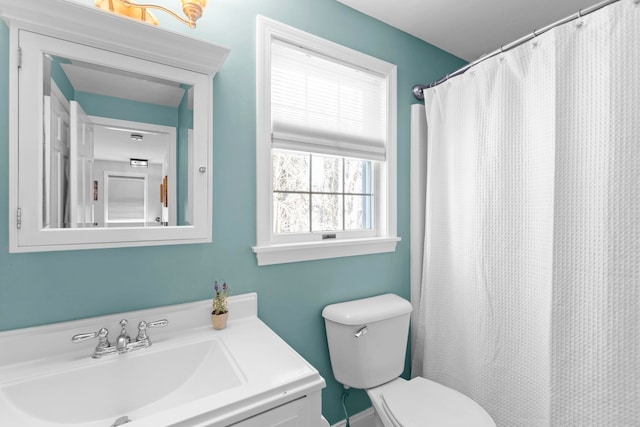 bathroom featuring sink, curtained shower, and toilet