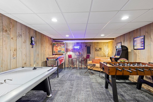 recreation room featuring carpet floors and wooden walls