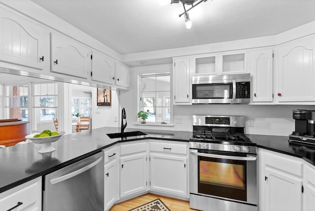 kitchen featuring white cabinetry, appliances with stainless steel finishes, sink, and light wood-type flooring