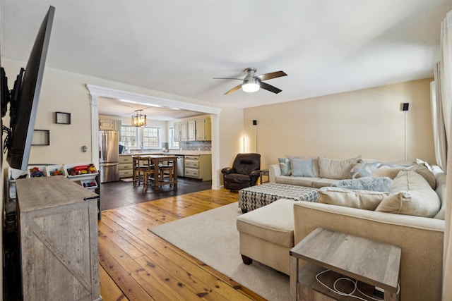 living room with dark wood-type flooring and ceiling fan