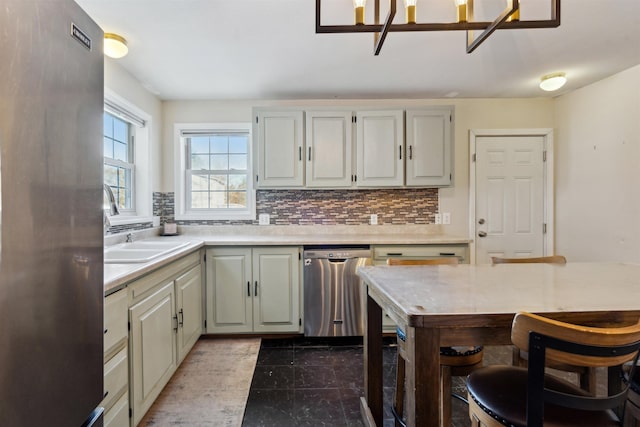 kitchen with appliances with stainless steel finishes, sink, and decorative backsplash