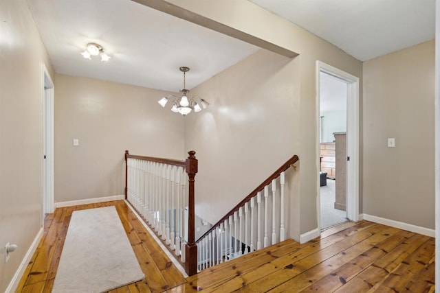 stairs with a chandelier and hardwood / wood-style floors