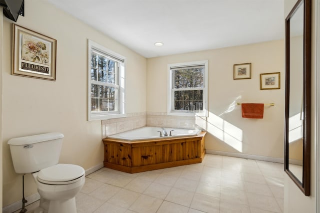 bathroom featuring a tub, a healthy amount of sunlight, and toilet