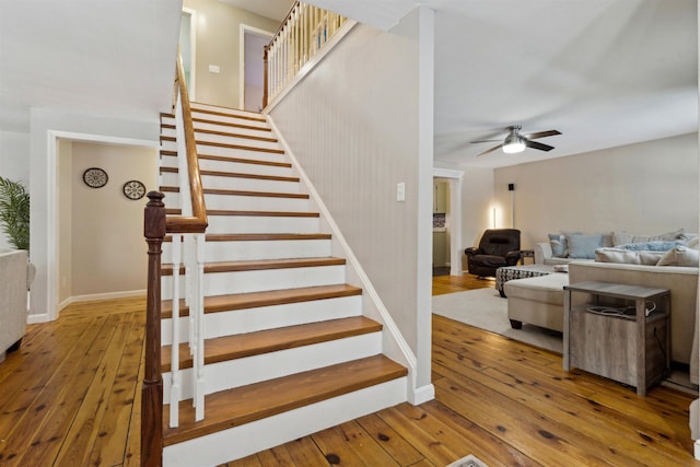 stairs featuring hardwood / wood-style floors and ceiling fan