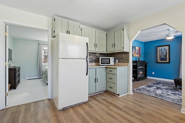 kitchen featuring ceiling fan, light wood-type flooring, backsplash, and white appliances