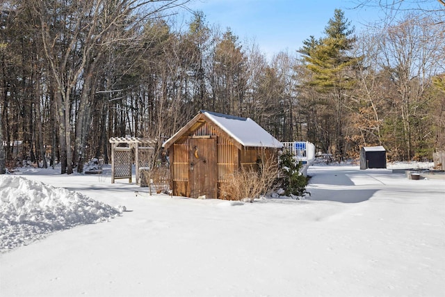 yard layered in snow featuring a shed