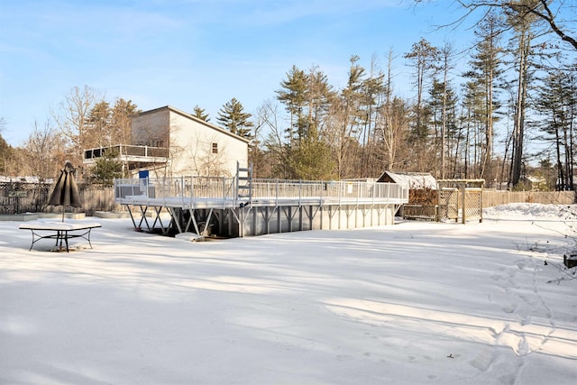 yard layered in snow with a pool side deck