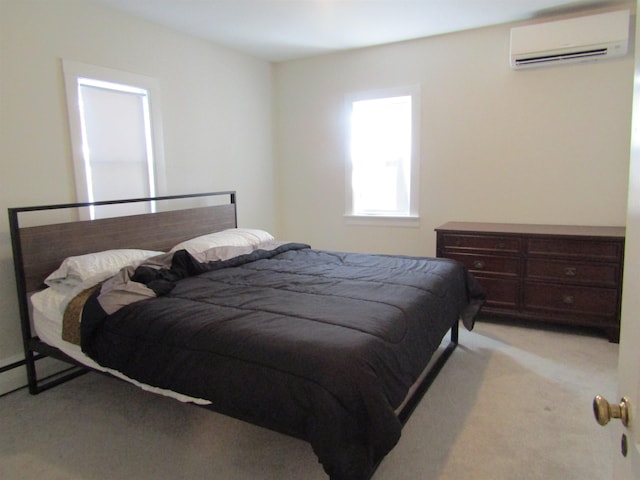 bedroom with an AC wall unit and light colored carpet