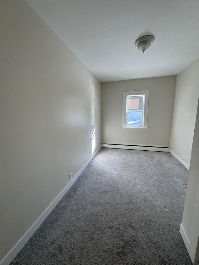 carpeted spare room with a baseboard radiator