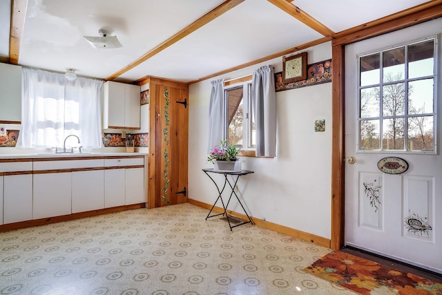 interior space with white cabinetry and sink