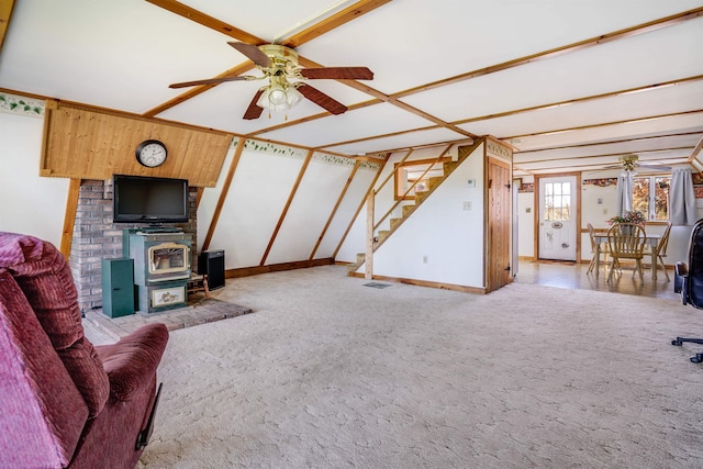 living room with a wood stove, ceiling fan, and carpet