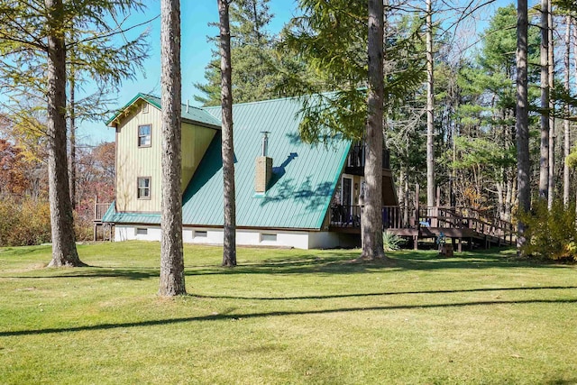 exterior space featuring a wooden deck and a lawn