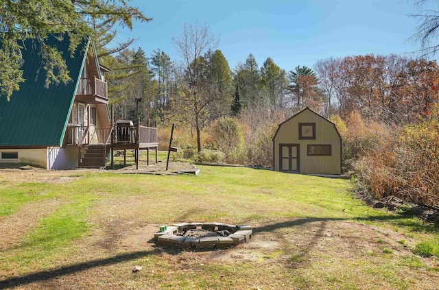 view of yard featuring a shed, a deck, and an outdoor fire pit