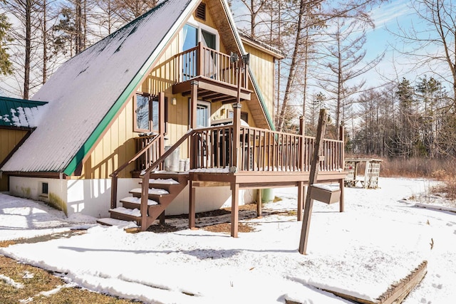 snow covered property with a deck