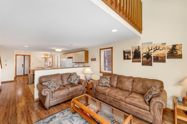 living room featuring an inviting chandelier and light wood-type flooring