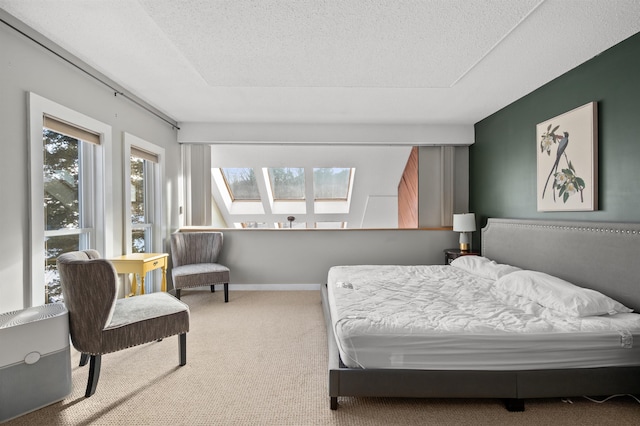 bedroom featuring carpet flooring, a textured ceiling, and a skylight