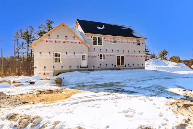 view of snow covered rear of property