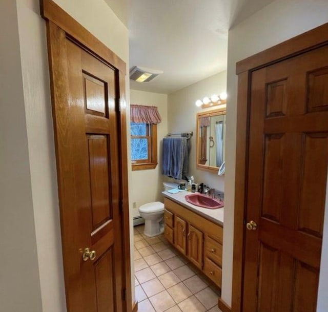 bathroom with a baseboard radiator, tile patterned floors, toilet, and vanity