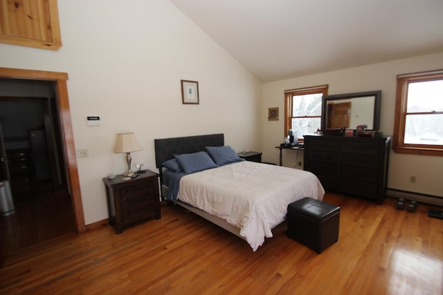 bedroom with multiple windows, hardwood / wood-style floors, and lofted ceiling