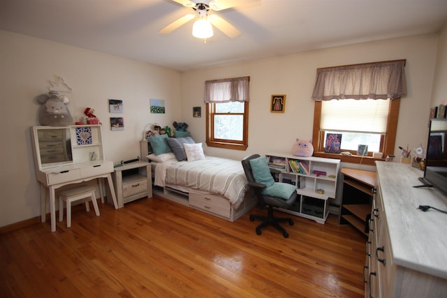 bedroom with ceiling fan, hardwood / wood-style floors, and multiple windows