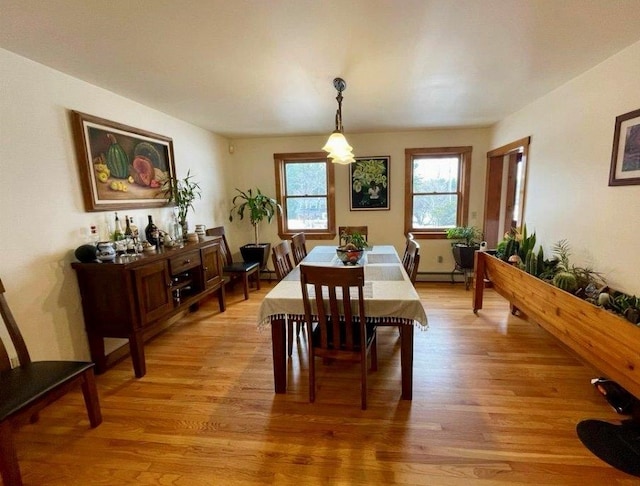 dining space with baseboard heating and light hardwood / wood-style flooring