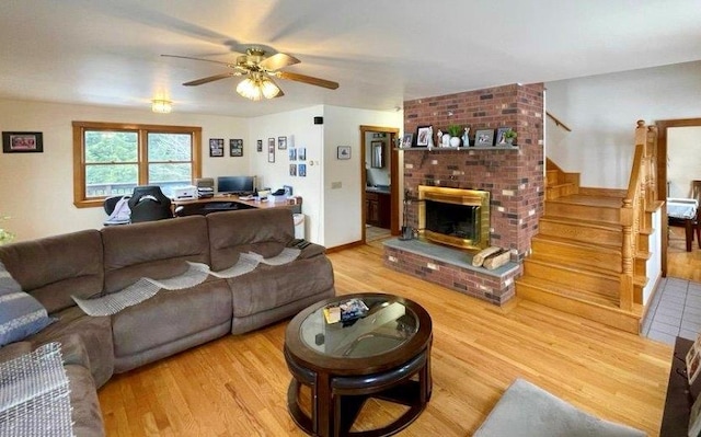 living room featuring ceiling fan, a fireplace, and hardwood / wood-style floors