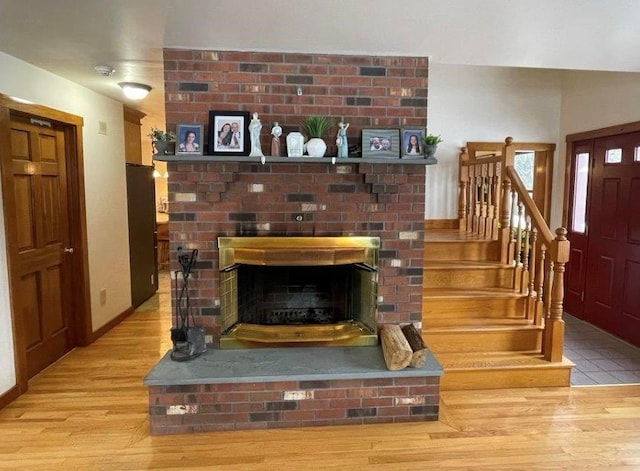 interior space with a brick fireplace and light wood-type flooring