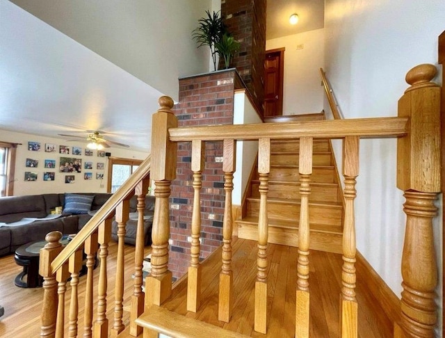 stairs with wood-type flooring and ceiling fan