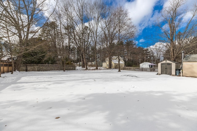 yard covered in snow with a storage shed