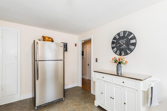 kitchen with stainless steel fridge and white cabinets