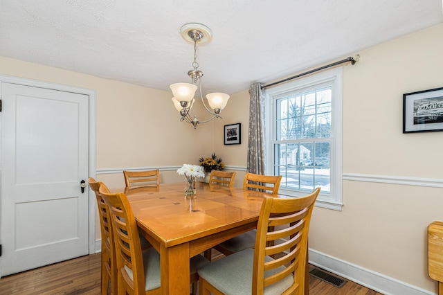 dining space featuring a notable chandelier and dark hardwood / wood-style flooring