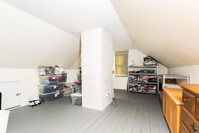 additional living space with hardwood / wood-style flooring and lofted ceiling