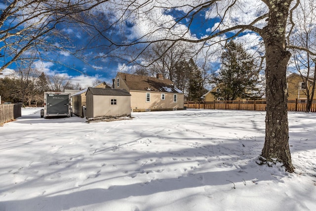 yard covered in snow featuring a shed