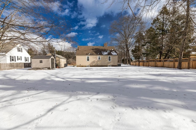 yard covered in snow featuring a storage unit