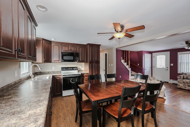 dining space featuring ceiling fan, a baseboard radiator, light hardwood / wood-style floors, and sink