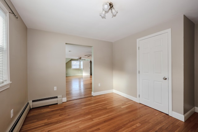 unfurnished room featuring a baseboard radiator and wood-type flooring