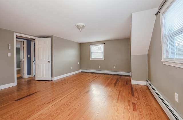 spare room with hardwood / wood-style flooring and a baseboard heating unit